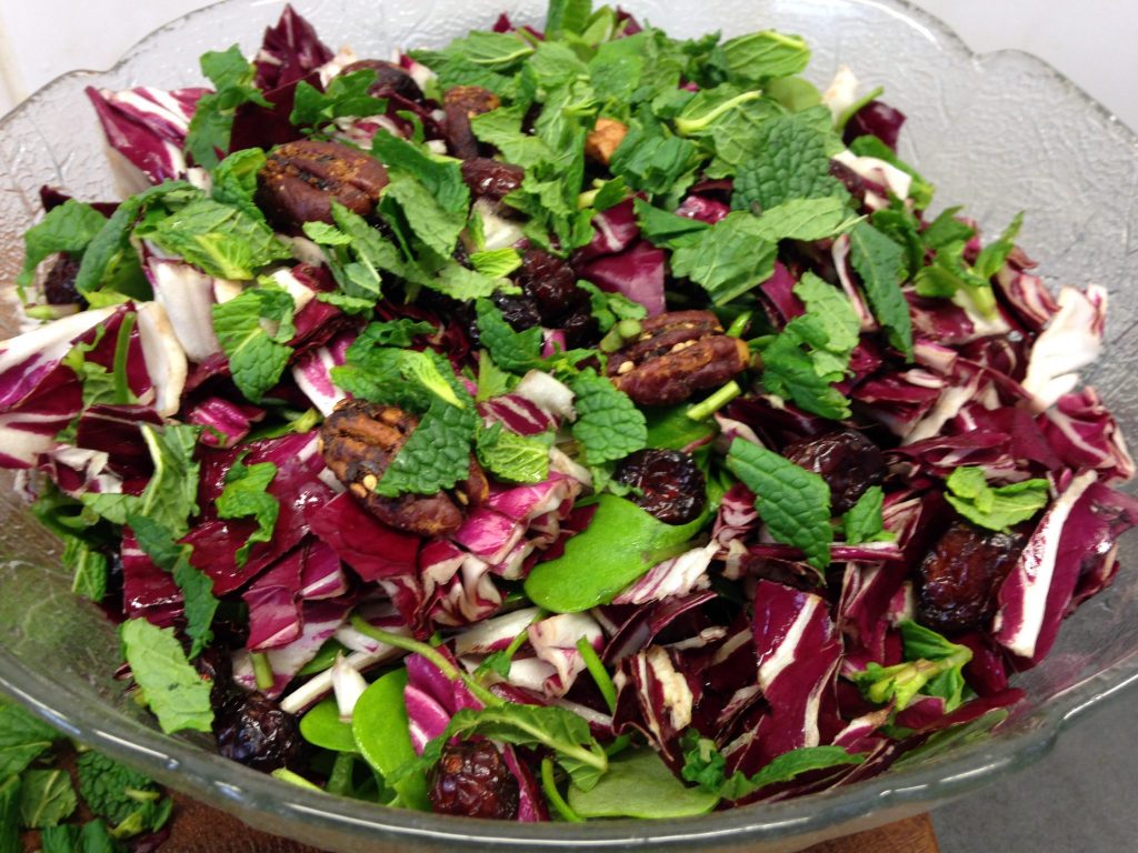 Postelein Salat mit Radicchio, Avocado, gerösteten Pecankernen, Cranberries, Granatapfelkernen, Frühlingszwiebeln und etwas Ziegenfeta. 