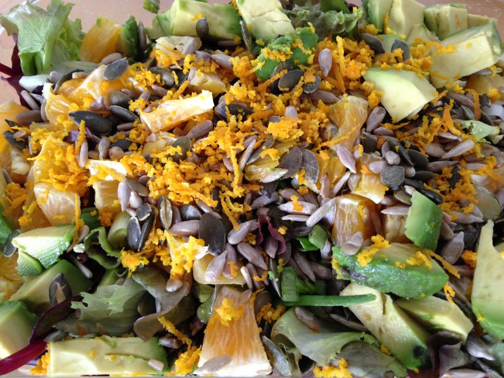 Blattsalat mit Orange, Avocado, Kürbiskernen und Oliven Vinaigrette