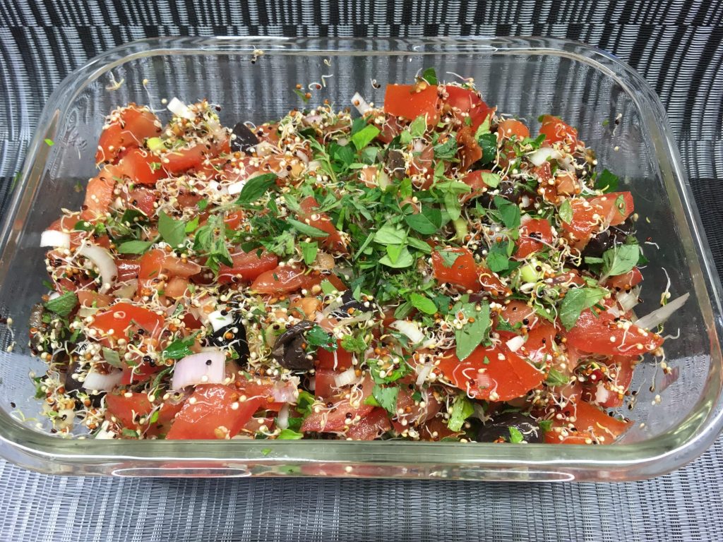Tomatensalat mit schwarzen Oliven, Quinoa Sprossen und Pesto Dressing