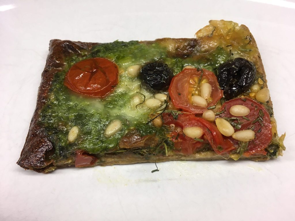 Pizza mit Pesto, Tomaten, Pinienkernen und Rucola